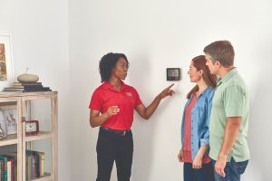 technician showing a thermostat